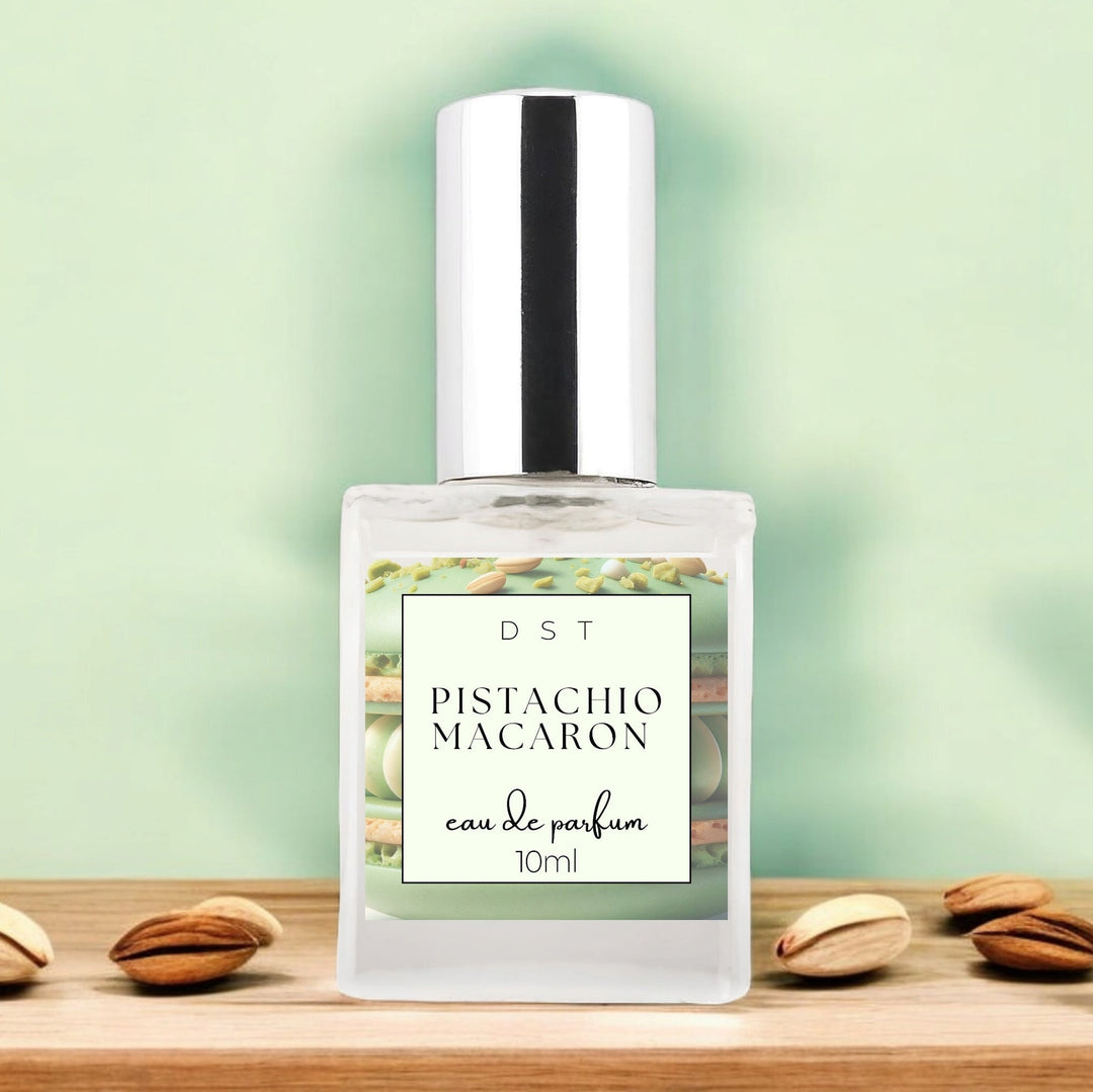 10ml bottle of Pistachio Macaroon Eau de Parfum sitting on wood counter top with pastel green background and pistachios surrounding the bottle.