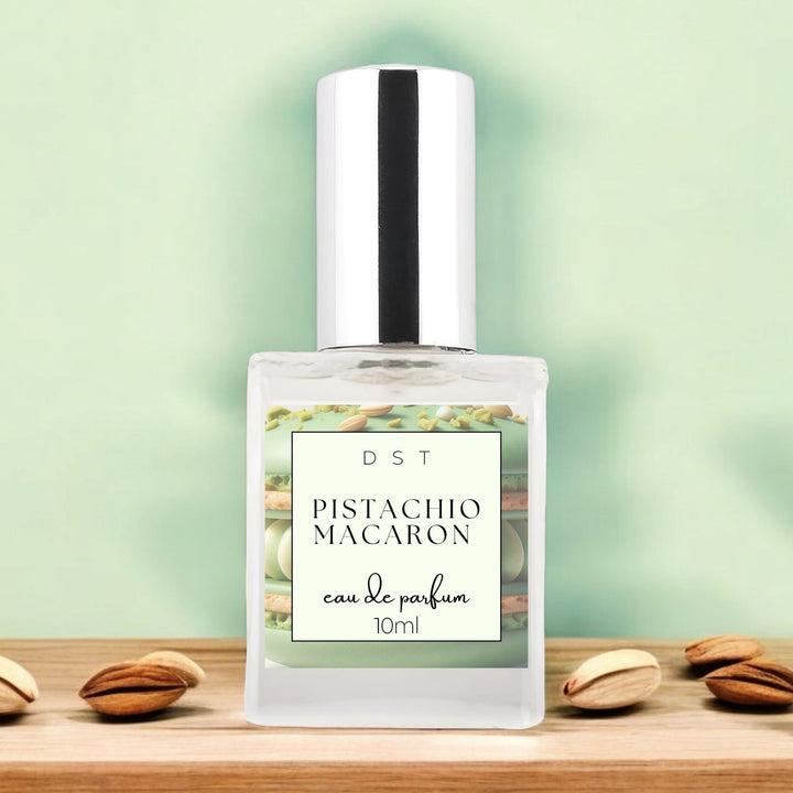 10ml bottle of Pistachio Macaroon Eau de Parfum sitting on wood counter top with pastel green background and pistachios surrounding the bottle.