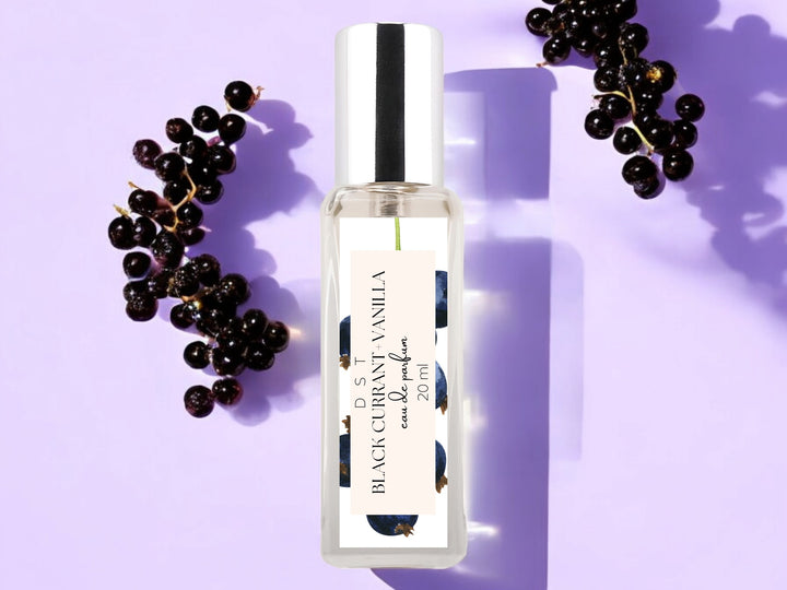 20ml bottle of black currant vanilla eau de parfum on purple background with black currants