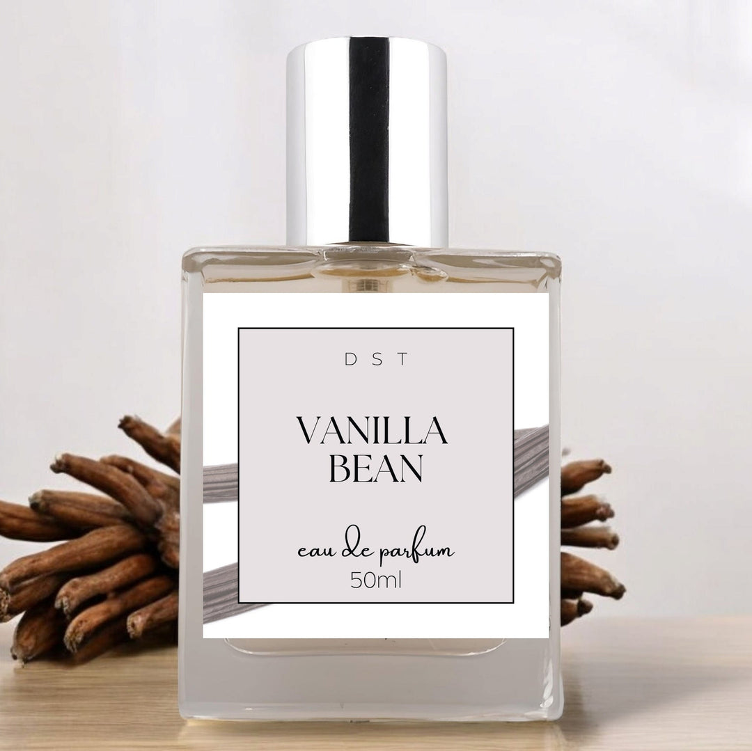 50ml bottle of Vanilla Bean Parfum sitting on a white countertop with a bundle of vanilla beans in the light grey background. 