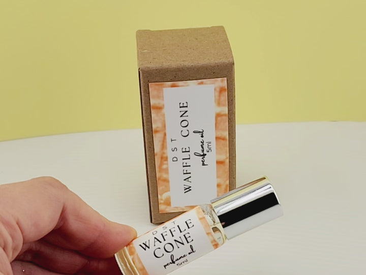 5ml bottle of Waffle Cone perfume oil and the box it is packaged in on white countertop with yellow background. 