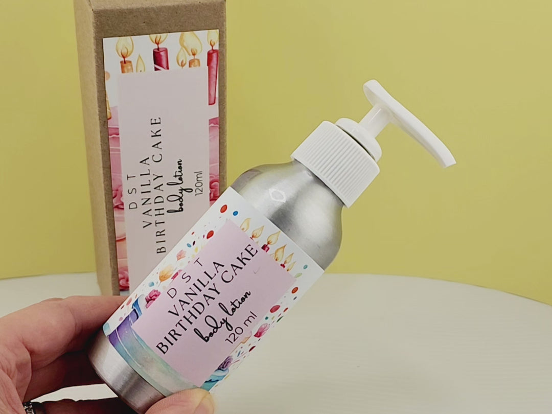 4oz Bottle of Vanilla Birthday Cake scented Body lotion and the box it is packaged in sitting on a white counter top with yellow background.