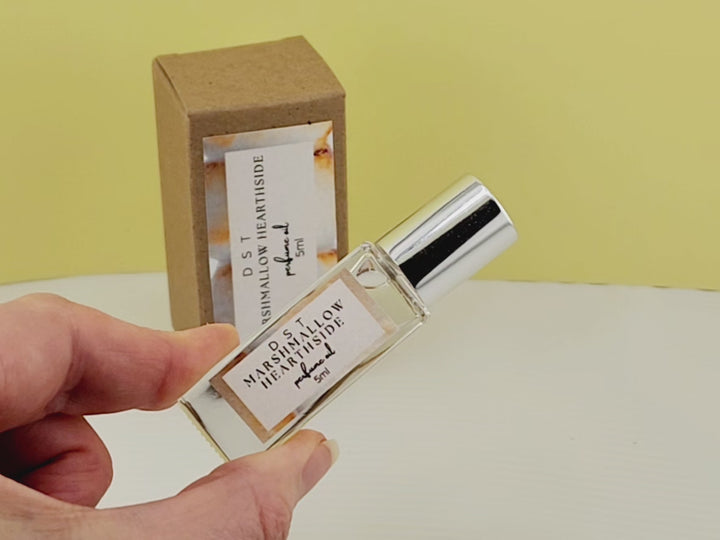 5ml bottle of Marshmallow Hearthside perfume oil and the box it is packaged in sitting on a white countertop with yellow background. 