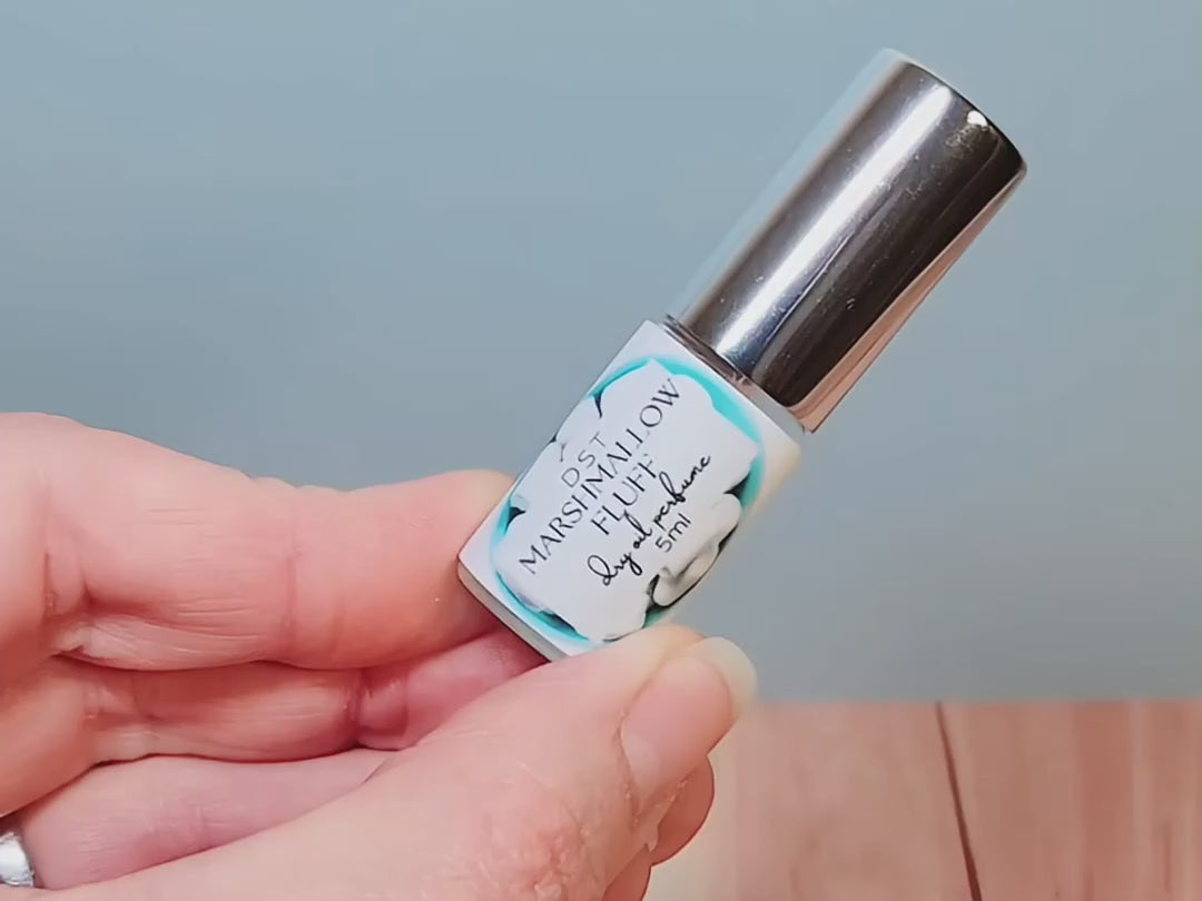 5ml bottle of Marshmallow Fluff Dry Oil Perfume Spray against a pastel blue background.